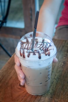 Take-home ice coffee cup on wooden table, stock photo