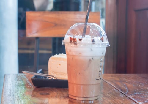 Take-home ice coffee cup on wooden table, stock photo