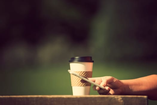 Woman holding smart phone outdoors