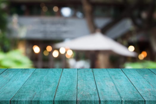 Perspective blue wooden table top with cafe blurred abstract background
