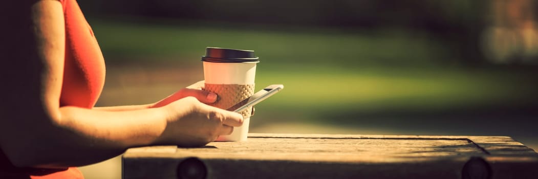 Woman holding smart phone outdoors