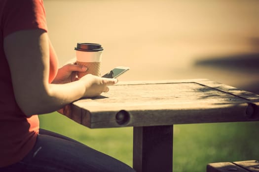 Woman holding smart phone outdoors