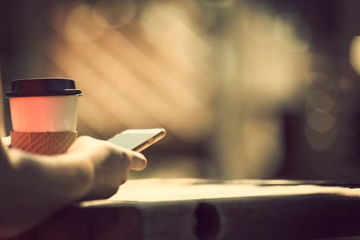Woman holding smart phone outdoors