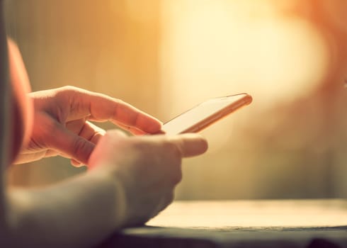 Woman holding smart phone outdoors
