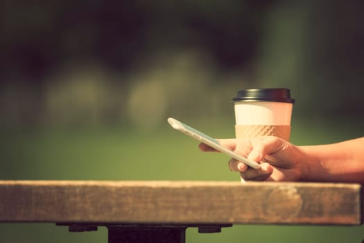 Woman holding smart phone outdoors