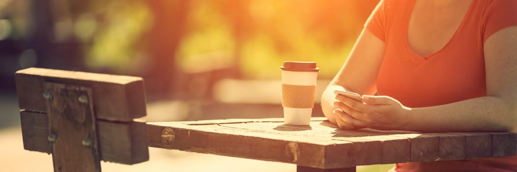 Woman holding smart phone outdoors