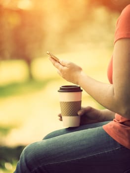 Woman holding smart phone outdoors