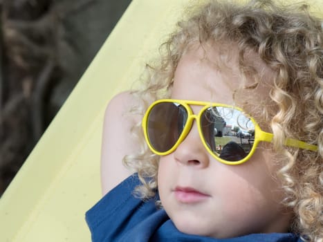 a  blond boy and yellow sunglasses