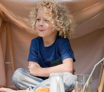 a boy with curly blond hair, to the outside