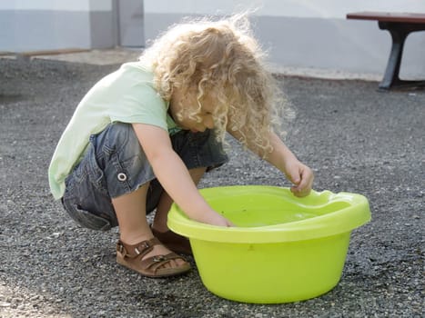 a  boy playing with water in the yard