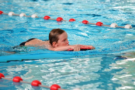 boy swimming with swimming board