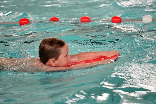 boy swimming with swimming board