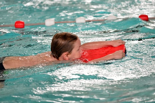 boy swimming with swimming board
