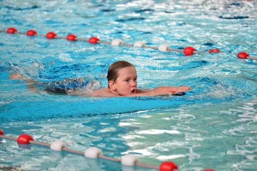 boy swimming with swimming board