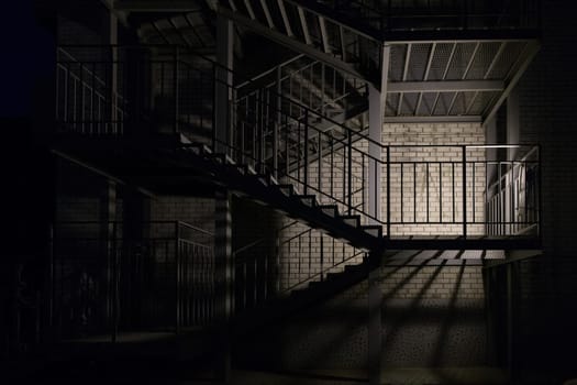 Outside staircase, illuminated by a lantern at night
