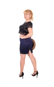 A midge woman in a skirt and black blouse holding a cowboy hat, .standing from back, isolated for white background..
