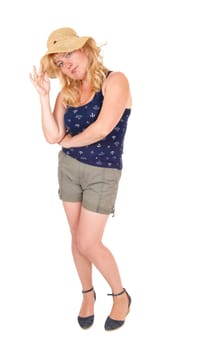 A middle age blond woman standing in shorts from the front wearing a.beige straw hat, isolated for white background..