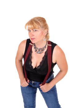 A woman in her forties standing in jeans and a black blouse with red.suspenders and a necklace, isolated for white background..