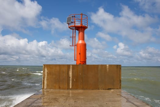 lighthouse at the end of pier with blue sky in background