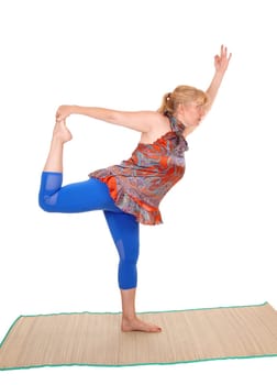 A pretty woman yoga trainer with blond hair standing on one leg and.stretching, isolated for white background..