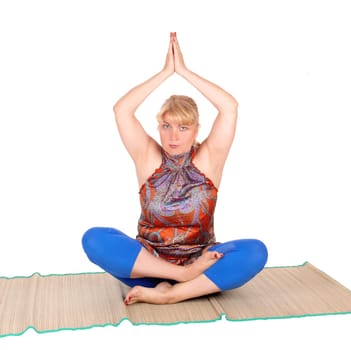 A beautiful blond woman sitting on the floor showing some nice yoga.poses, in a blue pants, isolated for white background..