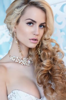 Portrait of a blonde bride with jewelry. Earrings and beads .
