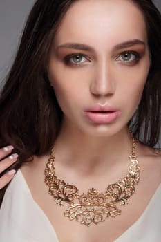 Caucasian attractive sexy fashion model with long brunette natural hair, beautiful eyes, full lips, perfect skin. Decoration of around his neck.