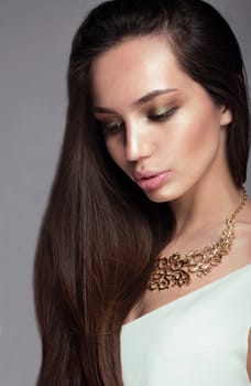 Glamour portrait of a woman looking down. Long hair, full lips, professional make-up.