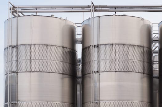 Three wine blending tanks glisten in the afternoon sun.