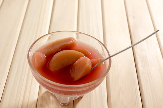 Compote of dried apple in the bowl on a wooden table