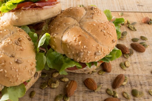 Sandwiches with fresh smoked meat, cheese, lettuce and tomato with homemade ketchup arranged with almond and pumpkin seeds