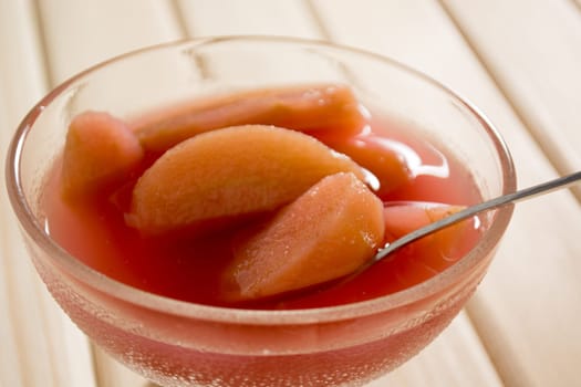 Apple compote on wooden table with spoon in the cup
