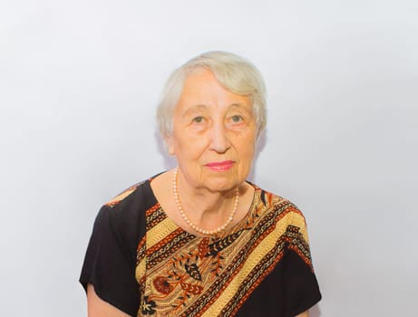 Old woman face portrait, aging process concept on gray