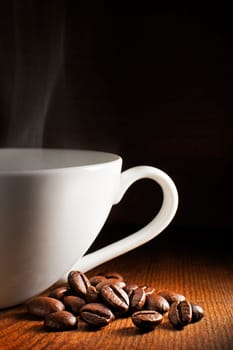 Coffee cup and beans on a wooden background.