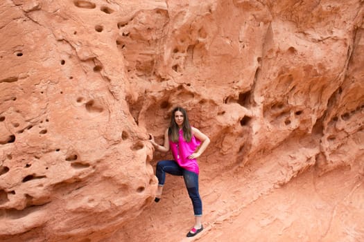 The young woman posing at Valley of Fire State Park, USA. The Valley of Fire State Park is the oldest state park in Nevada, USA and was designated as a National Natural Landmark in 1968.