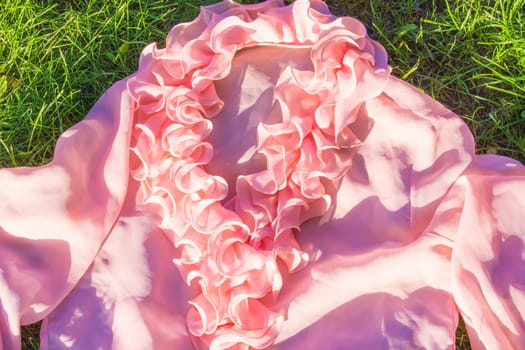 The pink female shirt against green grass