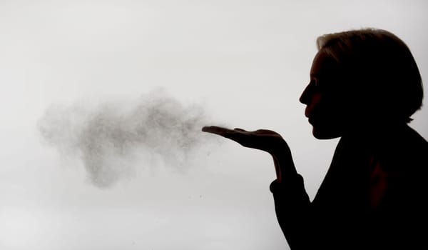 Woman blows dust