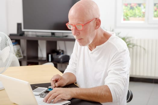 a mature man repaired a smartphone in his home
