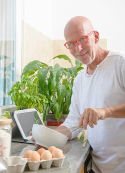 a senior man cooking in the kitchen at home
