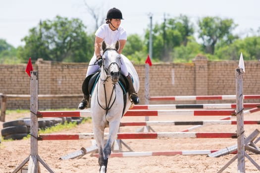 Volgograd, Russia - June 19, 2016: The sportswoman on a horse has successfully completed the jump across the barrier