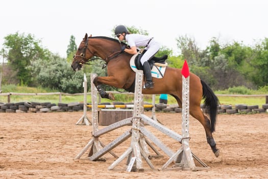 Volgograd, Russia - June 19, 2016: The athlete performs a jump on a horse through the barrier on the jumping competition
