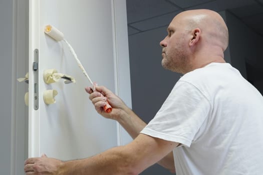 Craftsmen painting a door in an office building