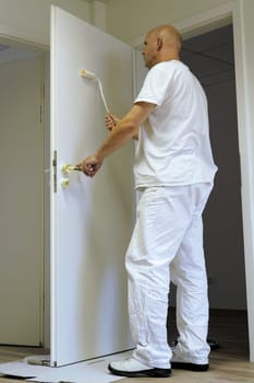 Craftsmen painting a door in an office building