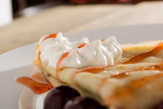 Fresh pancakes with cherry arranged on wooden table