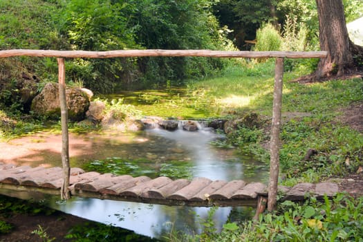 Small bridge over a water stream shoot with long exposure