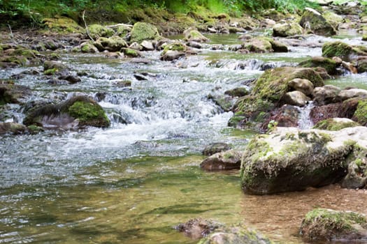Water stream running over mossy rocks