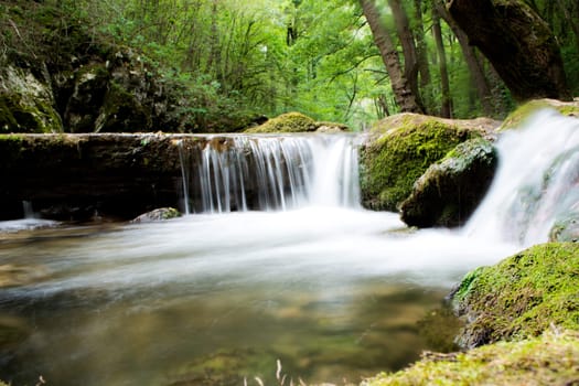 Water stream running over mossy rocks. Shoot with long exposure