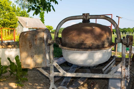 Rusty concrete mixer in  the back yard