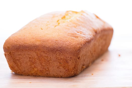 Lemon pound cake loaf uncut on cutting board.