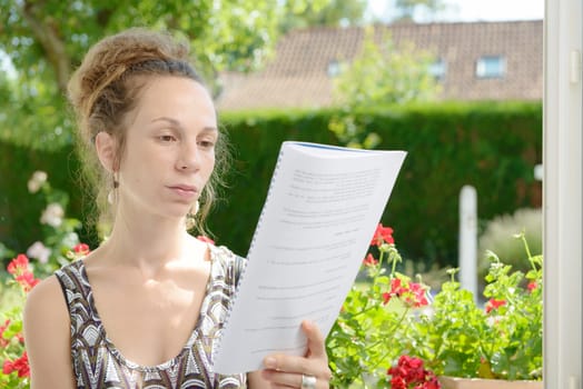 a beautiful young woman reads near the window